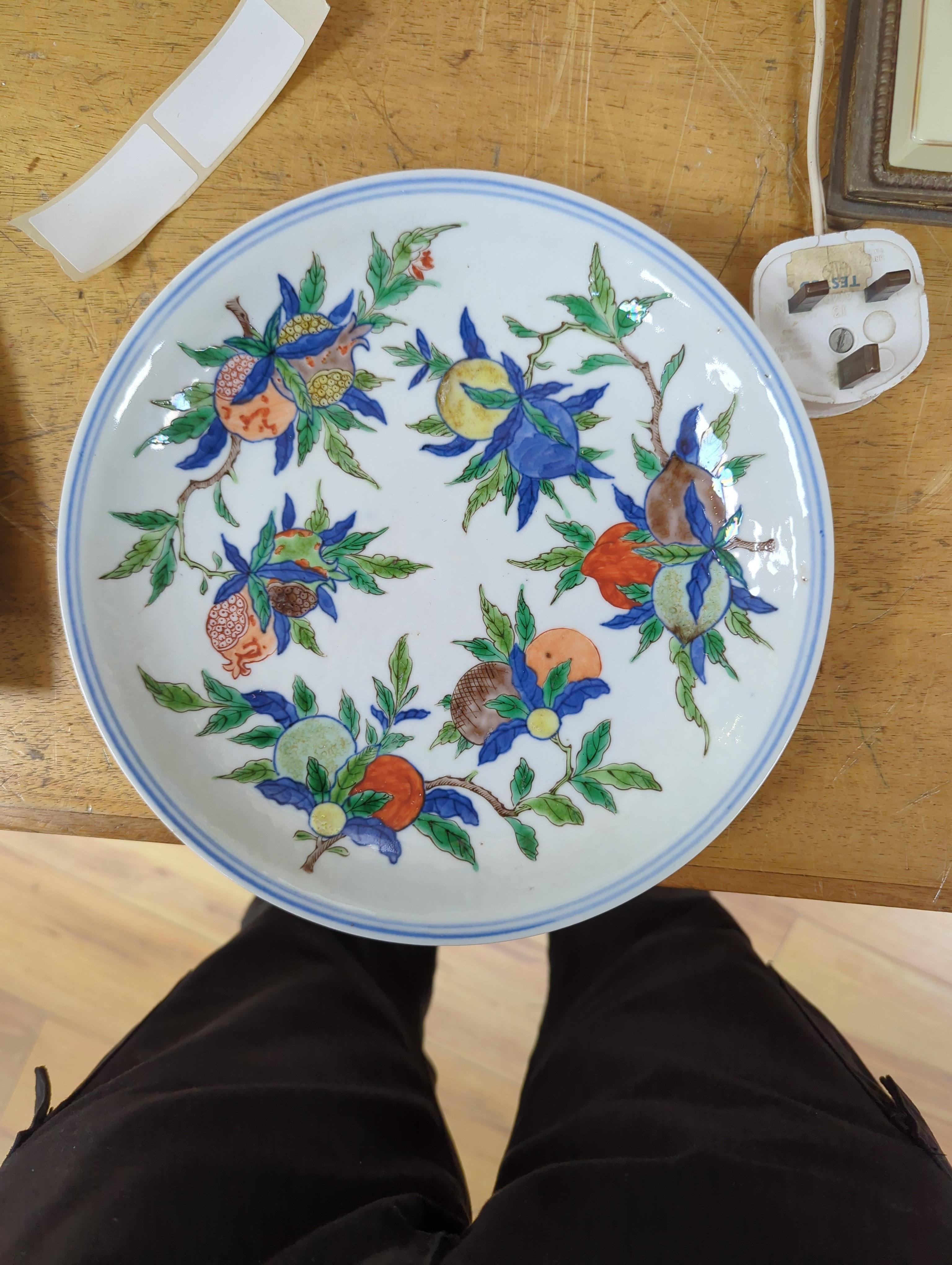 An 18th century Chinese famille rose bowl and a group of five Chinese wucai plates, each decorated with fruit, the bowl 23cm in diameter